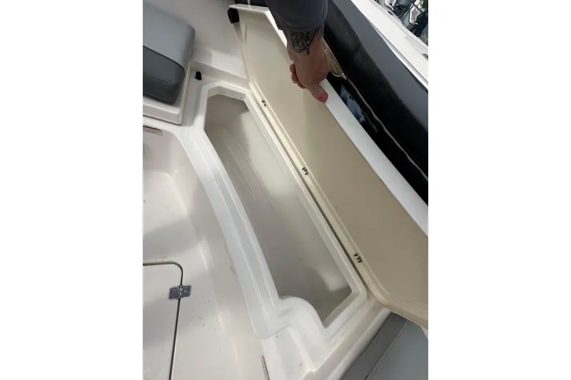 Slide: The Image of 2023 NAUTIC STAR 22 L boat storage compartment with open lid, showcasing interior space. - 29