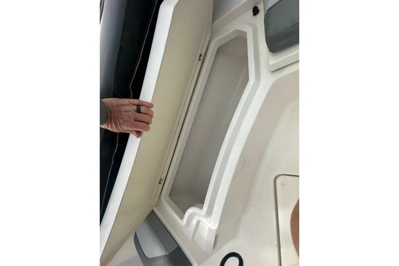 Slide: The Image of 2023 NAUTIC STAR 22 L boat storage compartment with hand opening lid. - 30