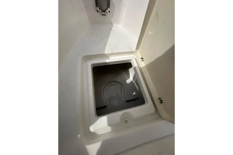 Slide: The Image of 2023 NAUTIC STAR 22 L boat storage compartment, open and empty, with visible hinges. - 35