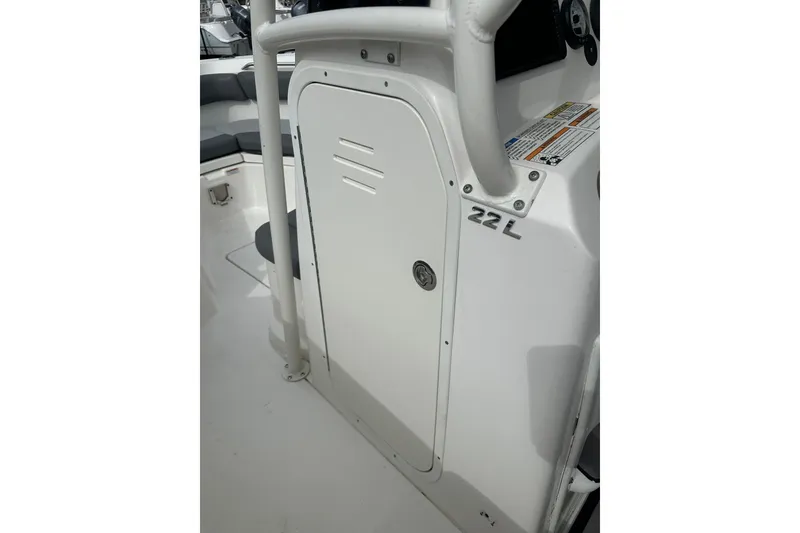 Slide: The Image of 2023 NAUTIC STAR 22 L boat console with storage compartment and seating area. - 38