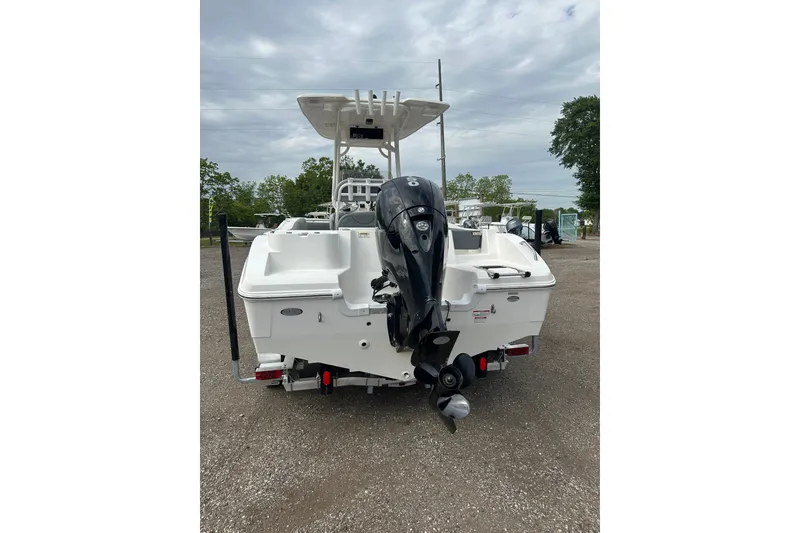 Slide: The Image of 2023 NAUTIC STAR 22 L boat with outboard motor, parked on gravel. - 4