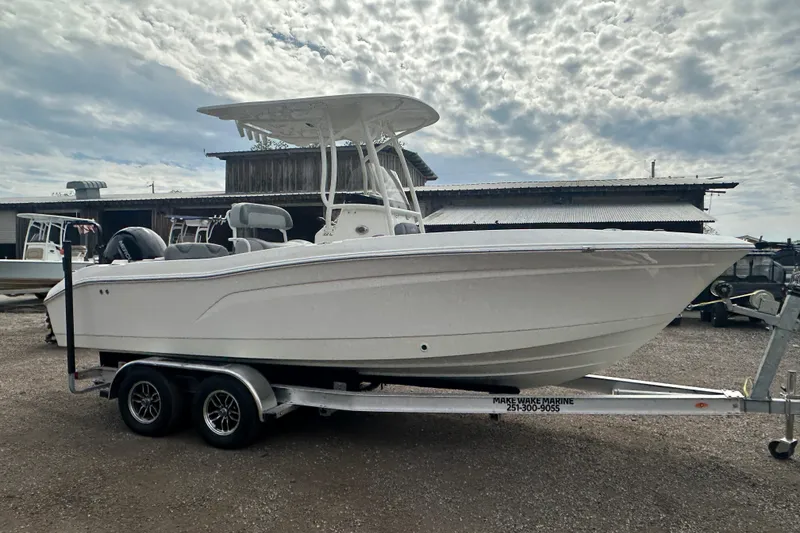 Slide: The Image of 2023 NAUTIC STAR 22 L boat on trailer, parked outdoors under cloudy sky. - 8