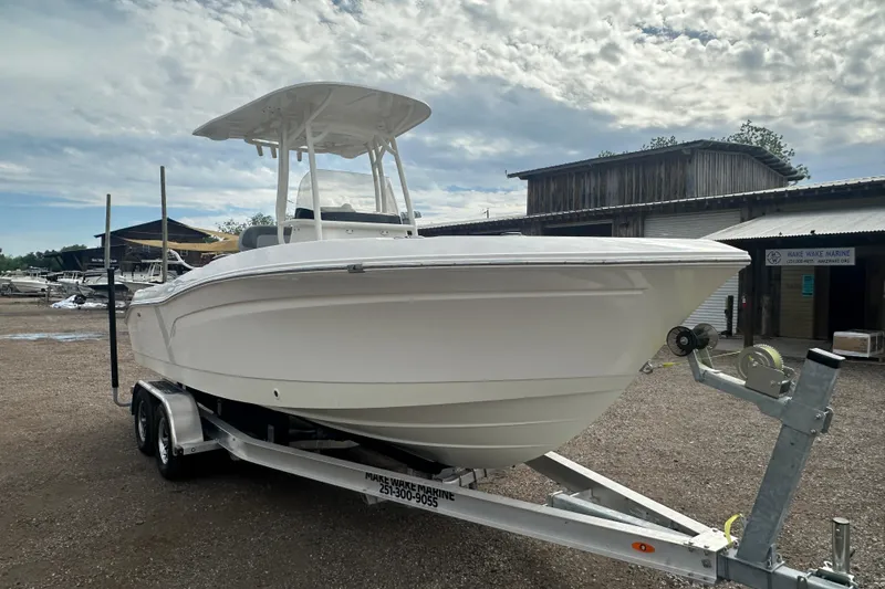 Slide: The Image of 2023 NAUTIC STAR 22 L boat on trailer, parked outdoors under cloudy sky. - 9