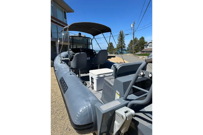 Slide: The Image of 2018 Sealegs 7.7 Amphibious RIB with canopy, parked near coastal homes. - 11