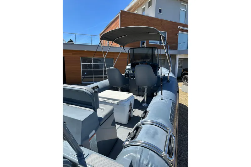 Slide: The Image of 2018 Sealegs 7.7 Amphibious RIB with canopy, parked near modern building. - 12