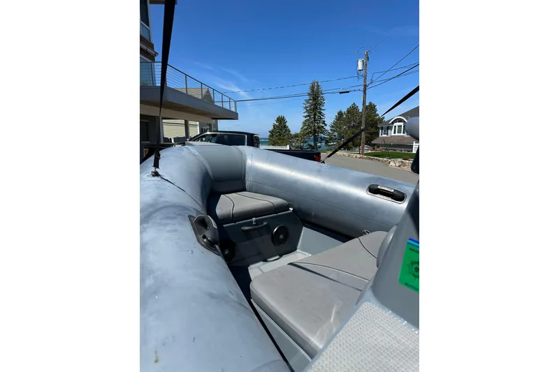 Slide: The Image of 2018 Sealegs 7.7 Amphibious RIB interior with seating, parked near waterfront homes. - 13
