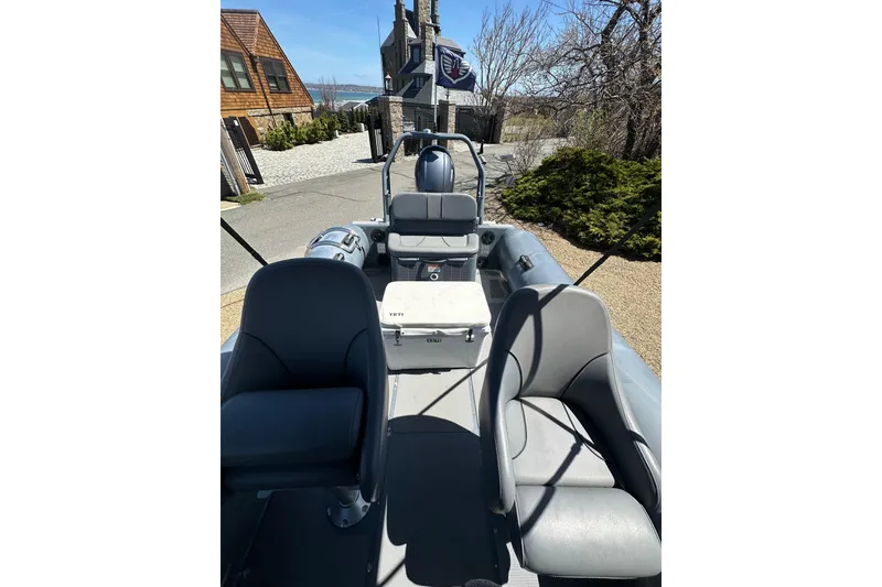 Slide: The Image of 2018 Sealegs 7.7 Amphibious RIB with seating, parked near coastal homes. - 17