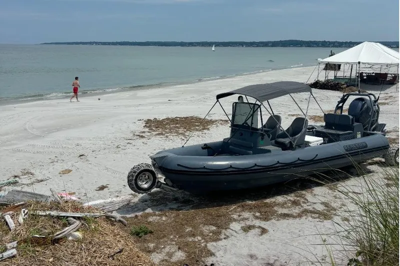 Slide: The Image of 2018 Sealegs 7.7 Amphibious RIB on sandy beach, ocean in background. - 2