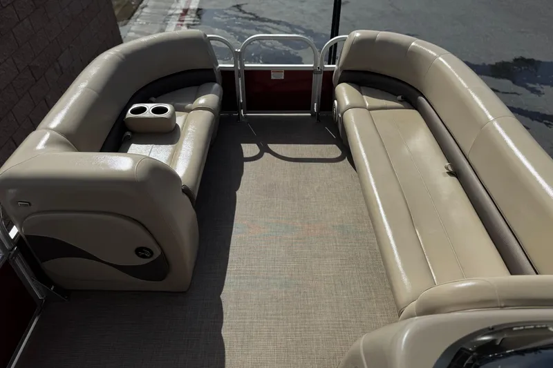 Slide: The Image of 2023 Sun Tracker Party Barge 18 DLX interior with beige seating and cup holders. - 10
