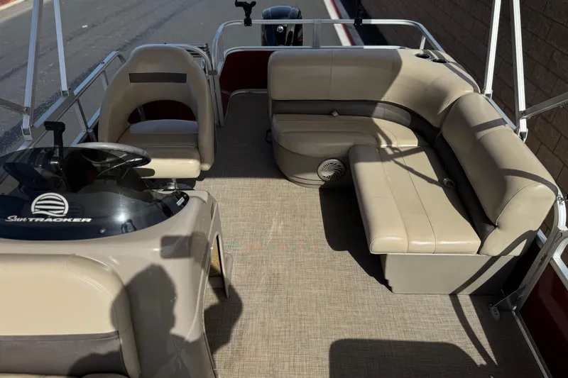 Slide: The Image of 2023 Sun Tracker Party Barge 18 DLX interior with beige seating and steering console. - 15