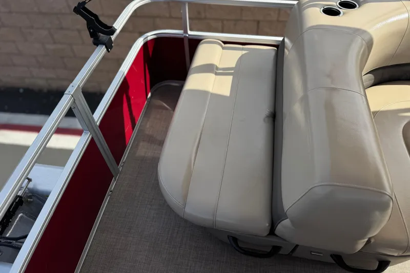 Slide: The Image of 2023 Sun Tracker Party Barge 18 DLX, beige seating, red paneling, cup holders, and railing. - 17