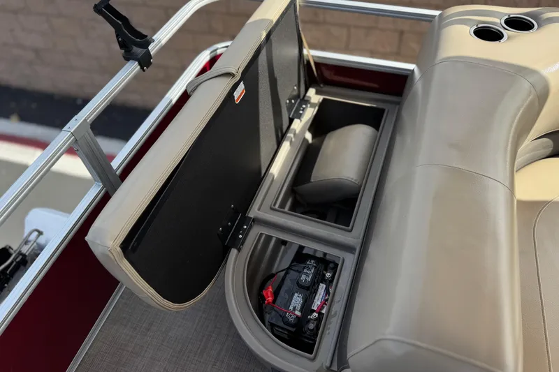 Slide: The Image of 2023 Sun Tracker Party Barge 18 DLX storage compartment with battery and cup holders. - 18