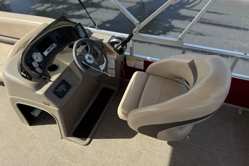 Slide: The Image of 2023 Sun Tracker Party Barge 18 DLX helm with beige captain's chair and control panel. - 21