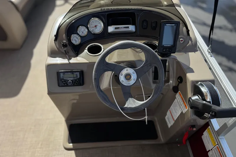 Slide: The Image of 2023 Sun Tracker Party Barge 18 DLX steering console with gauges and controls. - 23