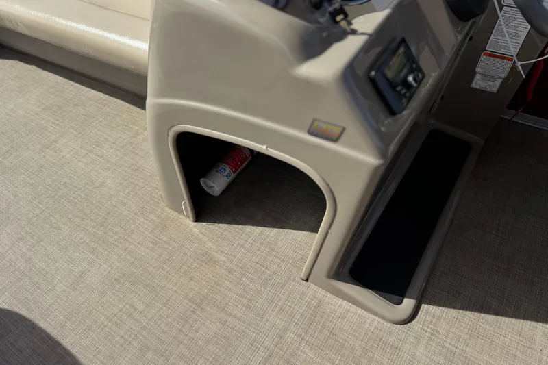 Slide: The Image of 2023 Sun Tracker Party Barge 18 DLX interior with storage compartment and beige flooring. - 24