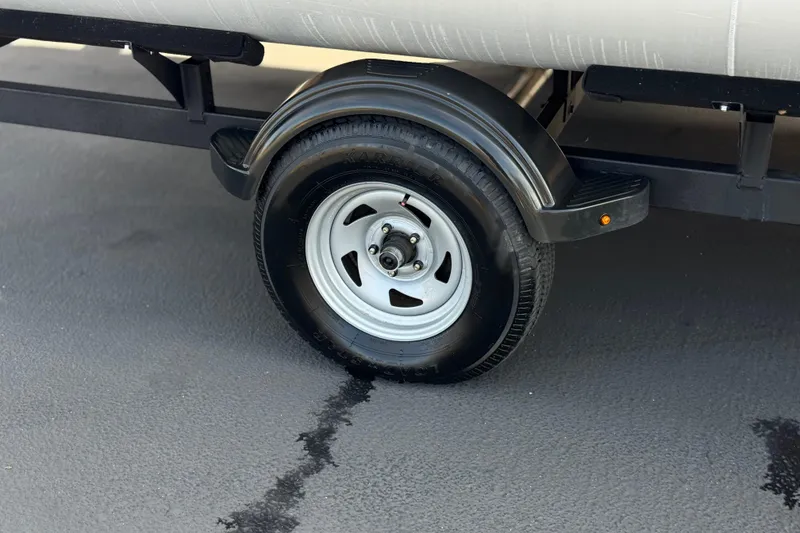 Slide: The Image of Trailer wheel of 2023 Sun Tracker Party Barge 18 DLX on asphalt surface. - 25