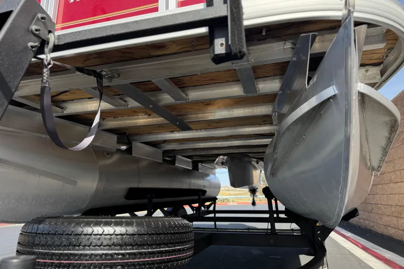 Slide: The Image of Underneath view of a 2023 Sun Tracker Party Barge 18 DLX pontoon boat on a trailer. - 4