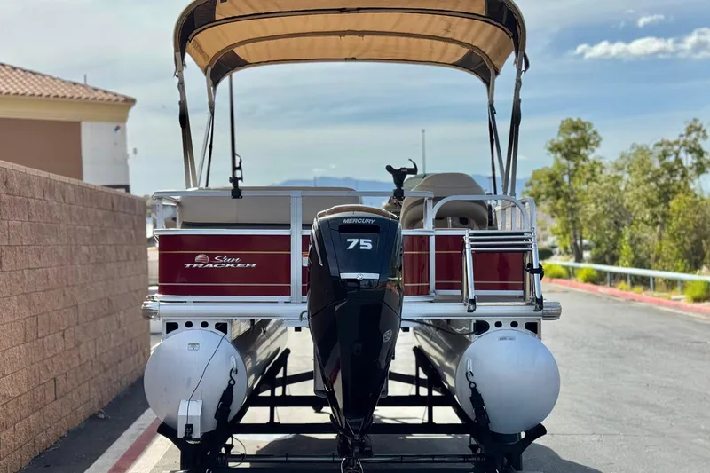 Slide: The Image of 2023 Sun Tracker Party Barge 18 DLX pontoon boat with Mercury 75 engine, parked outdoors. - 5