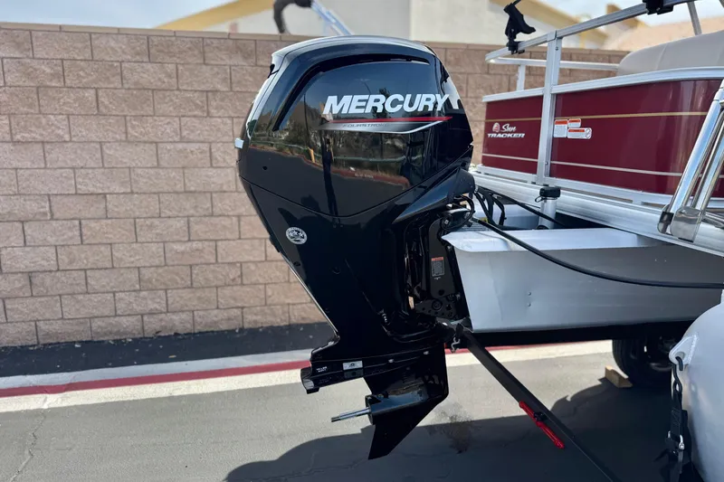 Slide: The Image of 2023 Sun Tracker Party Barge 18 DLX with Mercury outboard motor, parked on pavement. - 7
