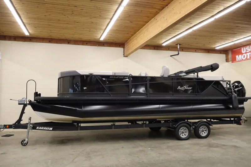 The Image of 2024 SunChaser Eclipse 8525 LR DH pontoon boat on trailer in indoor showroom. - 1