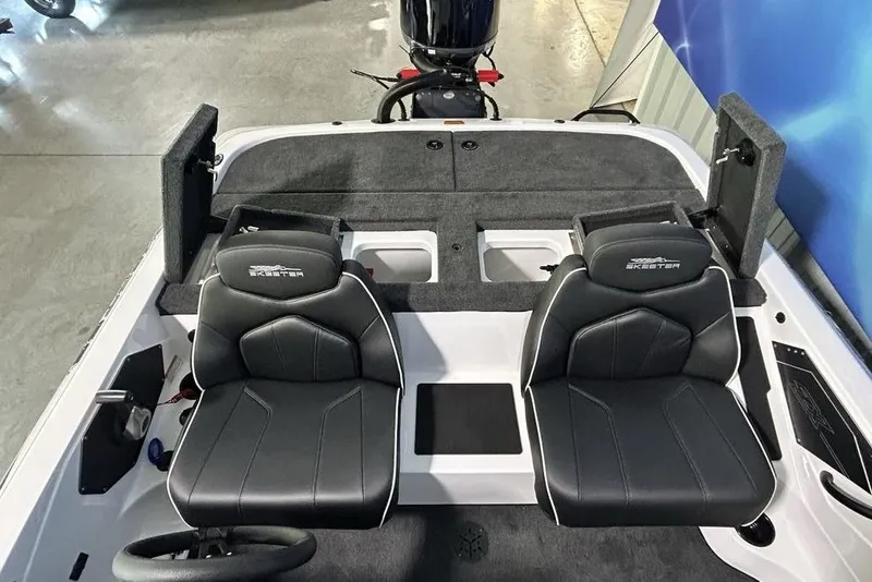 Slide: The Image of 2026 Skeeter ZX150 boat interior with dual black seats and steering wheel. - 17