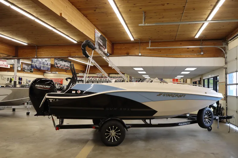 The Image of 2026 Starcraft SVX 191 OB boat displayed indoors on a trailer. - 1
