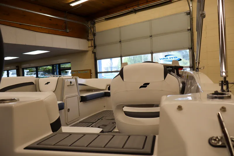 Slide: The Image of 2026 Starcraft SVX 191 OB boat interior, showcasing sleek seating and modern design in a showroom. - 4