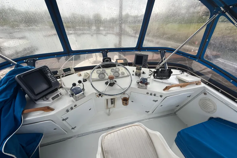 Slide: The Image of 1979 Uniflite 37 Coastal Cruiser helm with navigation equipment and blue canopy. - 12
