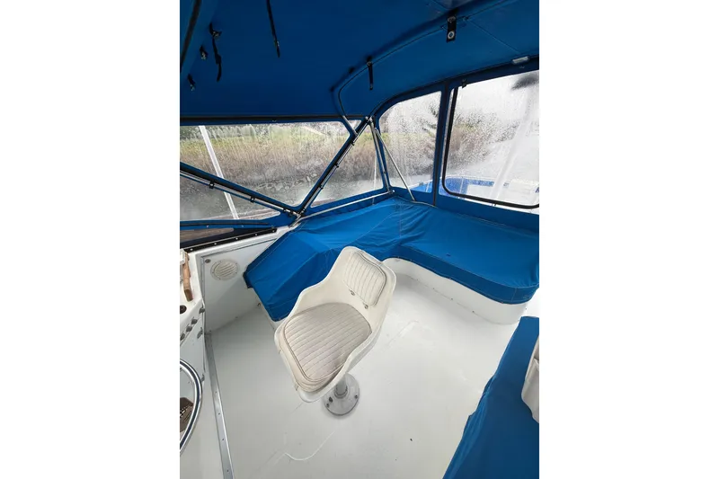 Slide: The Image of 1979 Uniflite 37 Coastal Cruiser interior with blue seating and white captain's chair. - 16