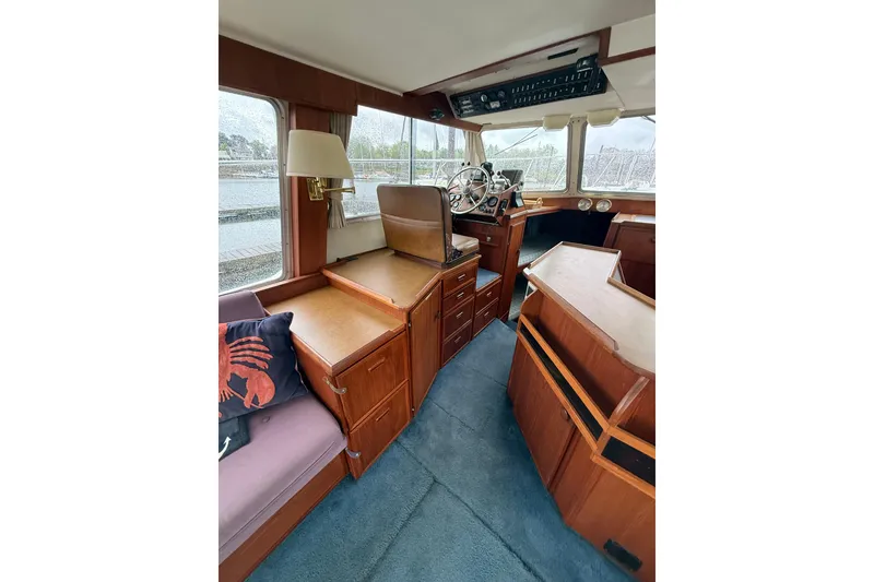Slide: The Image of 1979 Uniflite 37 Coastal Cruiser interior with wood cabinetry and steering wheel. - 20