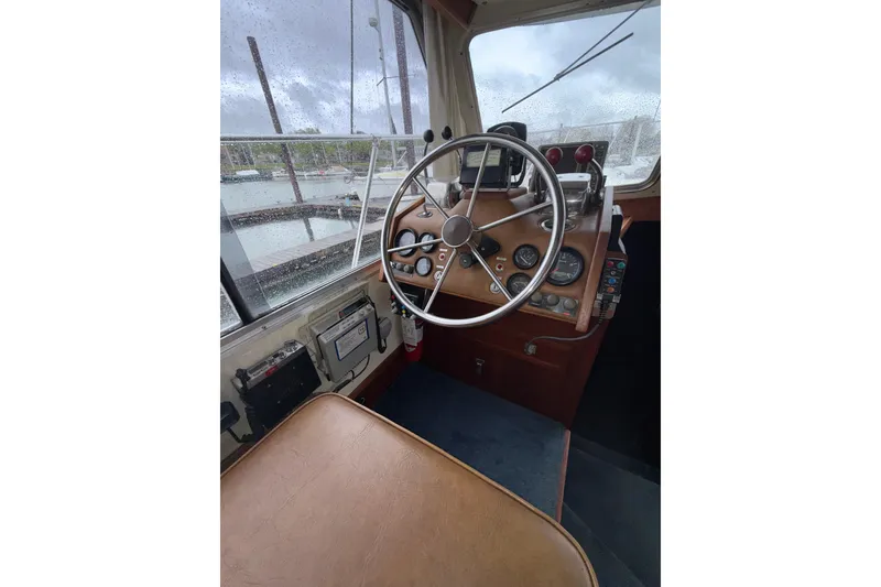 Slide: The Image of 1979 Uniflite 37 Coastal Cruiser helm with steering wheel and control panel. - 33