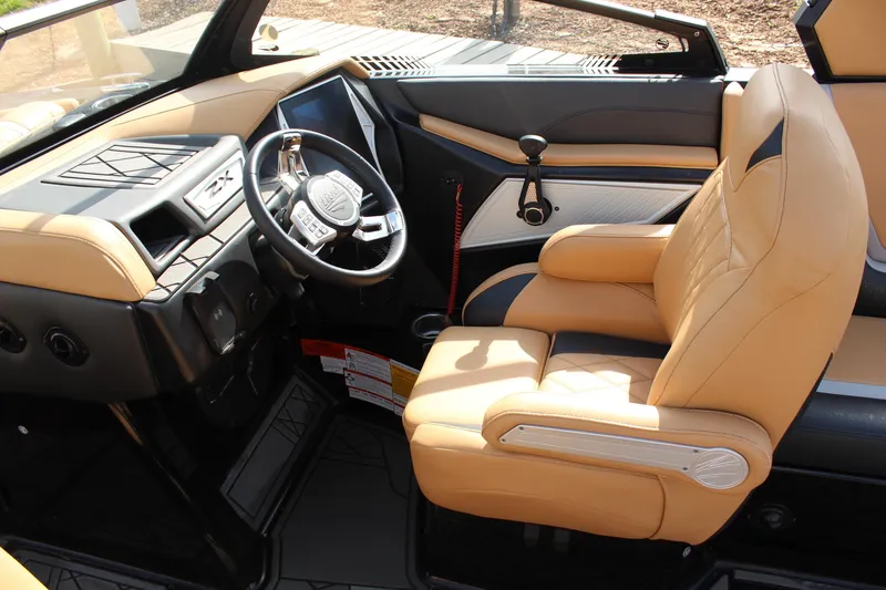 Slide: The Image of 2022 Tigé 23ZX boat interior with tan leather seating and modern dashboard controls. - 14