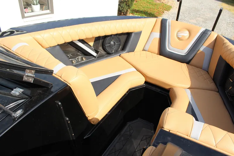 Slide: The Image of 2022 Tigé 23ZX boat interior with tan and gray seating, cup holders, and speaker. - 15