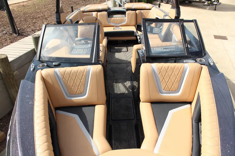 Slide: The Image of 2022 Tigé 23ZX boat interior with tan and black seating, open windshield. - 17