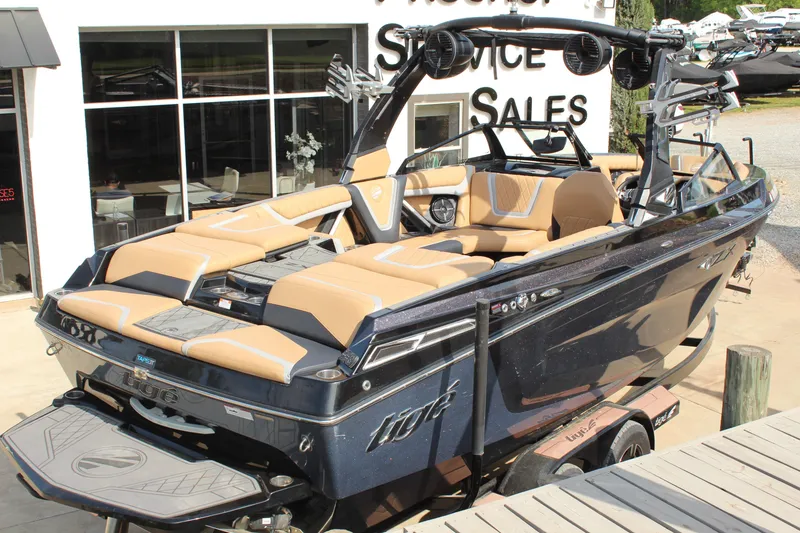 Slide: The Image of 2022 Tigé 23ZX boat with tan seating, displayed at a sales location. - 3