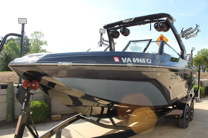 Slide: The Image of 2022 Tigé 23ZX boat on trailer, sleek design, parked outdoors. - 6