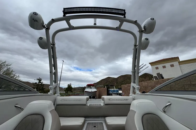 Slide: The Image of 2022 Crownline 220 SS SURF boat interior with wakeboard tower under cloudy sky. - 17