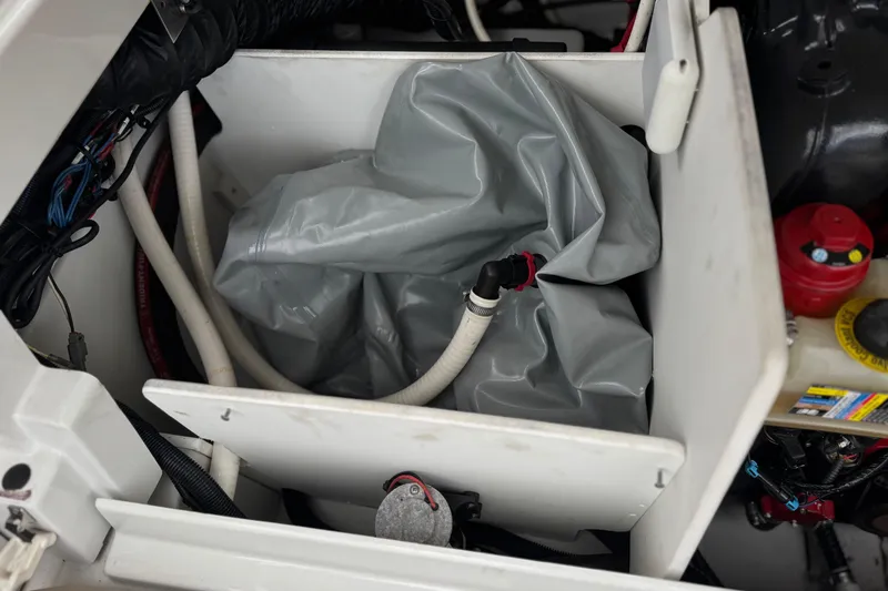 Slide: The Image of Engine compartment of 2022 Crownline 220 SS SURF boat, featuring hoses and components. - 24