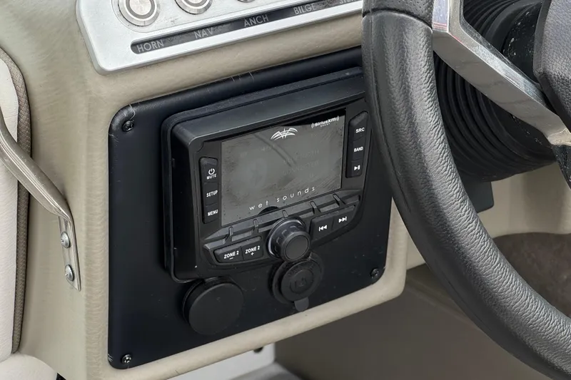 Slide: The Image of Control panel of 2022 Crownline 220 SS SURF boat with audio system and steering wheel. - 32