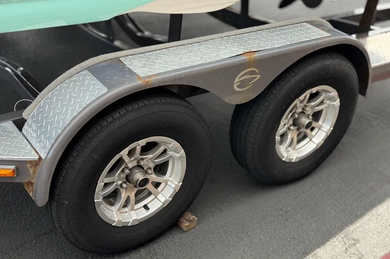 Slide: The Image of Trailer wheels of a 2022 Crownline 220 SS SURF boat on pavement. - 37