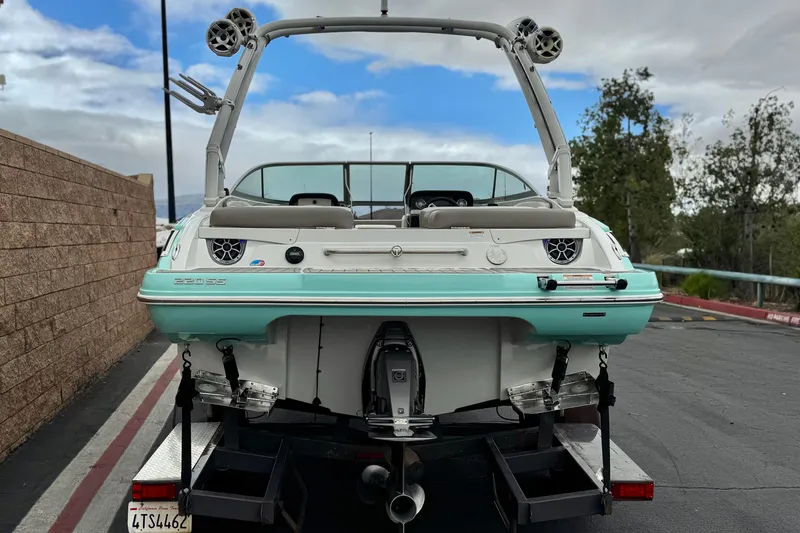 Slide: The Image of 2022 Crownline 220 SS SURF boat on trailer, rear view, parked outdoors. - 4