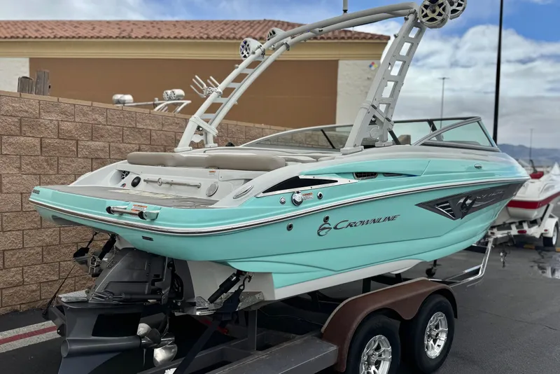 Slide: The Image of 2022 Crownline 220 SS SURF boat on trailer, featuring sleek design and vibrant turquoise color. - 5