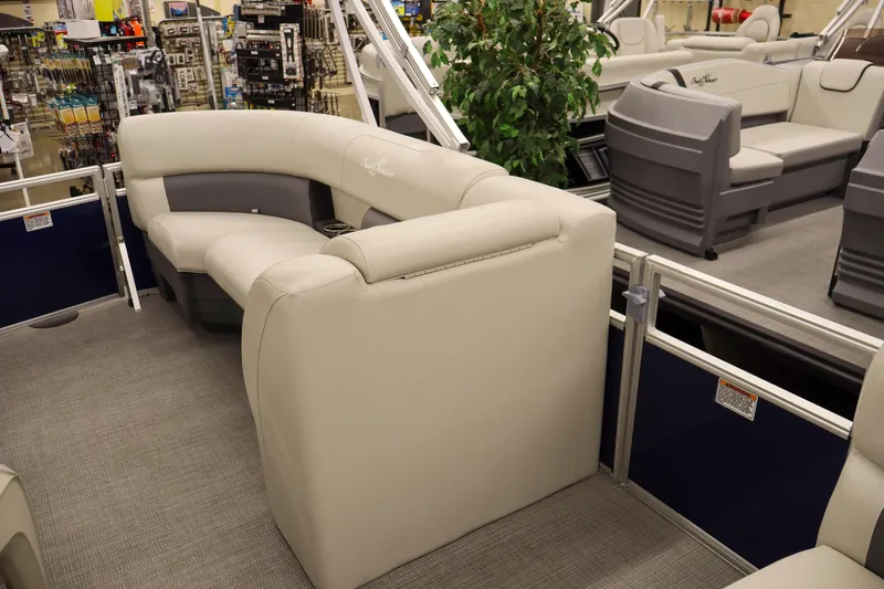Slide: The Image of 2025 SunChaser Vista 18 Fish pontoon boat interior with plush seating in showroom. - 10