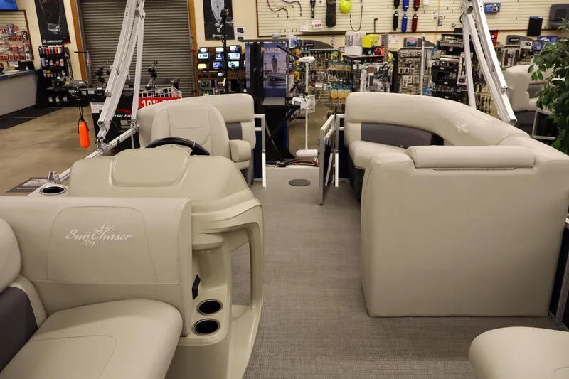 Slide: The Image of 2025 SunChaser Vista 18 Fish pontoon boat interior in showroom, featuring plush seating and modern design. - 7