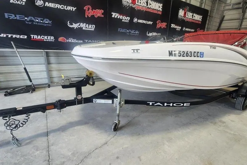 Slide: The Image of 2022 Tahoe T16 boat on trailer in showroom with branded backdrop. - 3