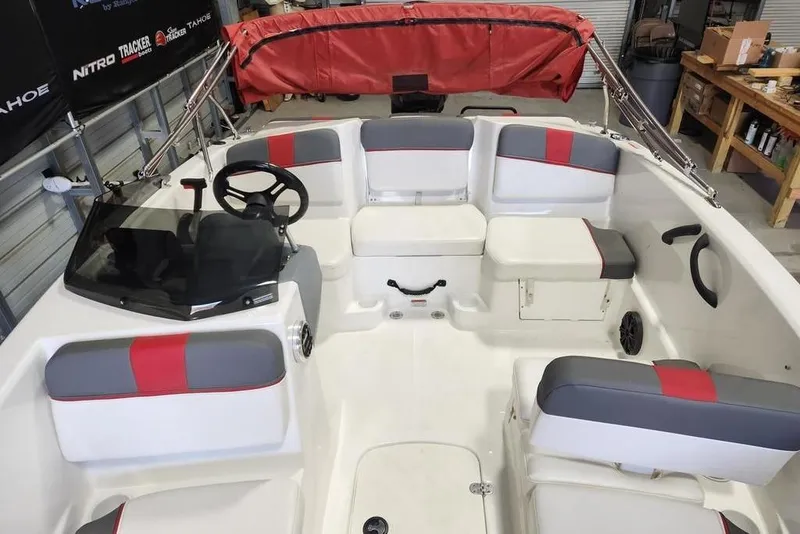 Slide: The Image of 2022 Tahoe T16 boat interior with red and gray seating, steering wheel, and storage compartments. - 8