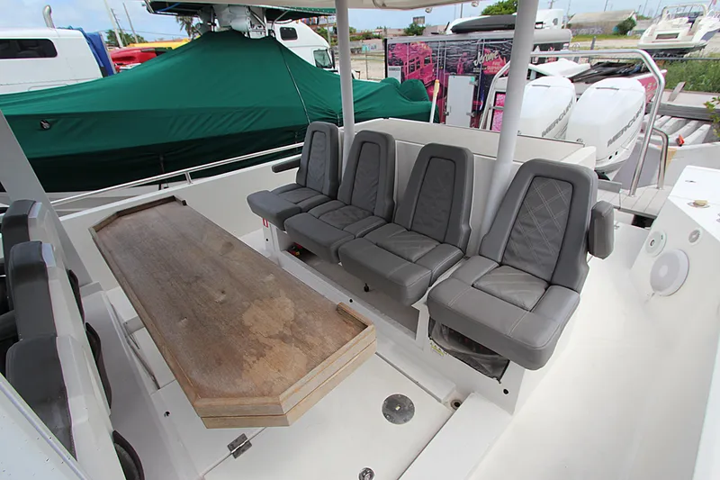 Slide: The Image of 2018 Axopar 37 Sun-Top boat interior with gray seating and wooden table. - 3