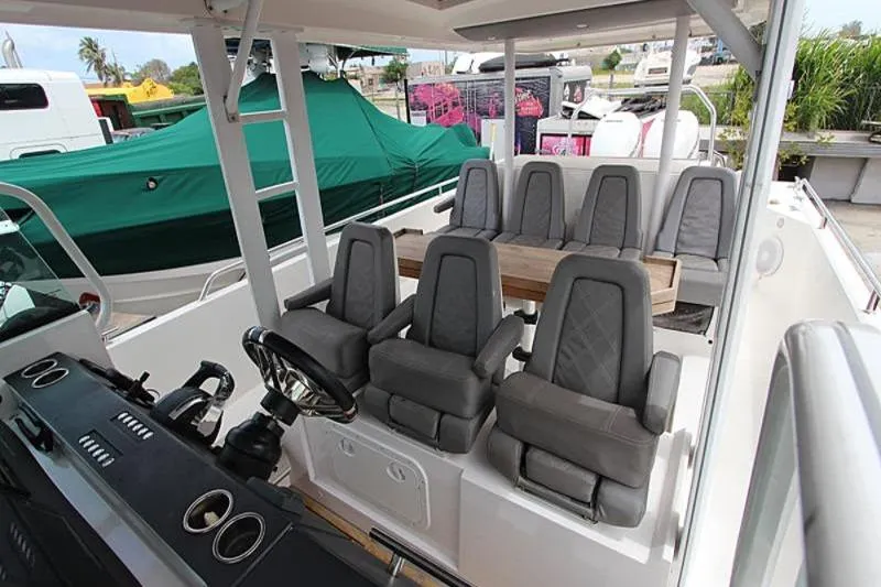 Slide: The Image of 2018 Axopar 37 Sun-Top boat interior with gray seating and steering wheel. - 5