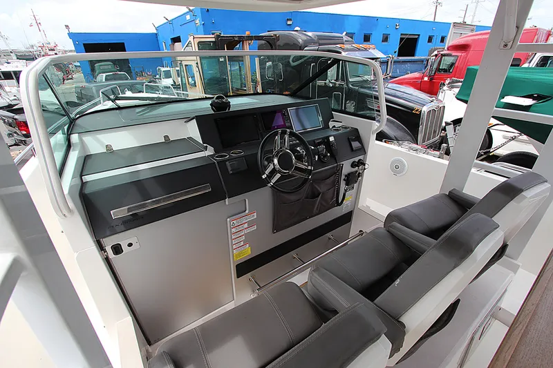 Slide: The Image of 2018 Axopar 37 Sun-Top boat cockpit with steering wheel and navigation controls. - 7