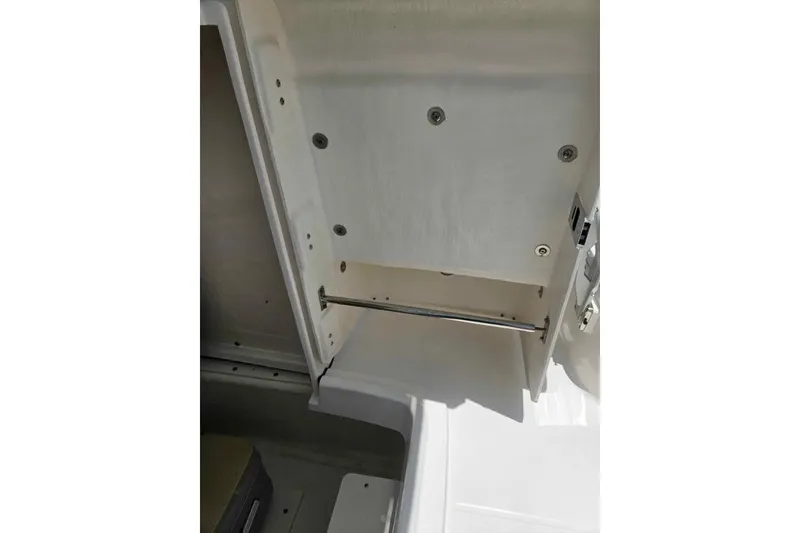 Slide: The Image of Storage compartment inside 2021 Robalo R202 Explorer boat, featuring a sleek white interior. - 15